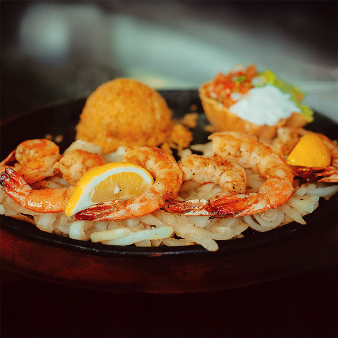 Grilled shrimp on onions with rice at Maria Mia Tex-Mex Cantina Restaurant Bar College Station.