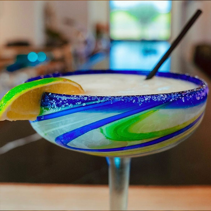 A margarita glass at Maria Mia Tex-Mex Cantina in Texas, rimmed with salt and a lime wedge.