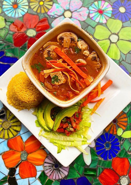 A bowl of soup with veggies, rice, and avocado at Maria Mia Tex-Mex Cantina in College Station.