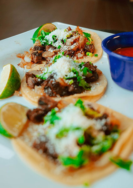 Three beef tacos with cheese, cilantro, lime, and salsa at Maria Mia Tex-Mex Cantina in Texas.