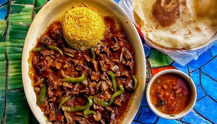 Oval plate with beef stew, peppers, rice & beans at Maria Mia Tex-Mex Cantina in College Station.