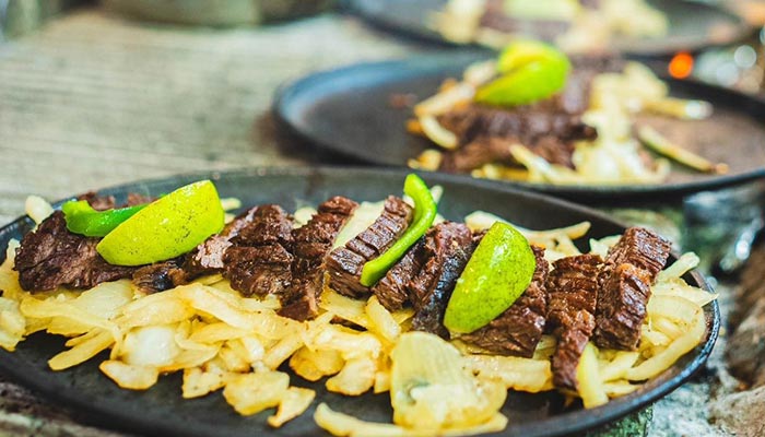 Grilled steak with onions, lime wedges at Maria Mia Tex-Mex Cantina Restaurant, College Station.